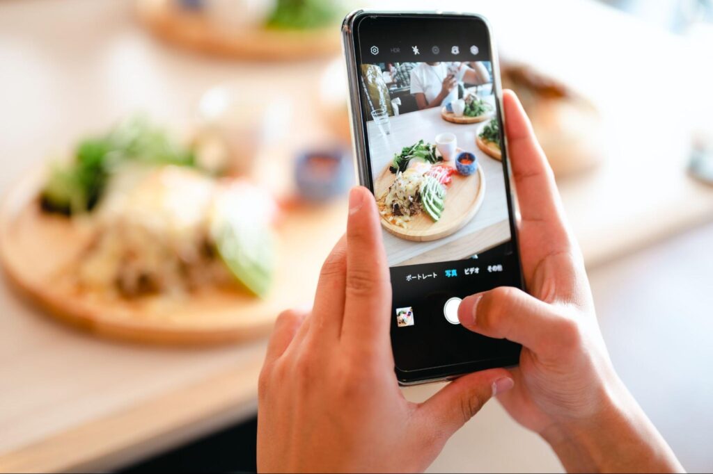 SNSにスマホで写真を投稿する様子